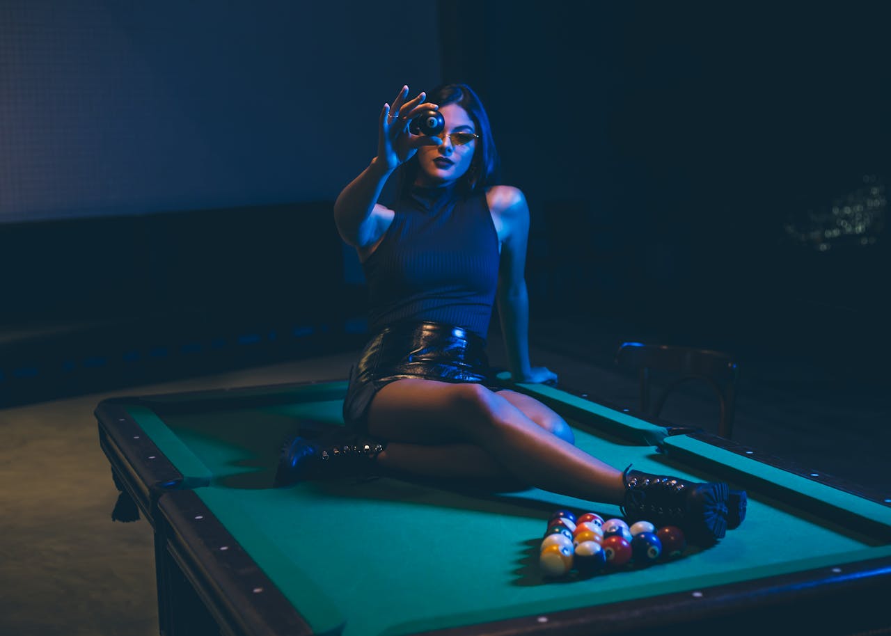 Elegant woman poses on a billiard table, combining fashion with leisure.